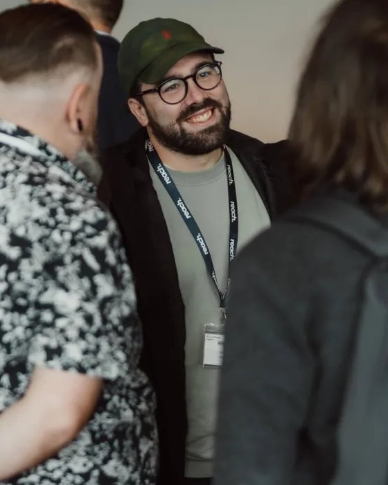 Drew Hajduk, HR software product designer and founder of PAYgrade, talking with people at an HR industry event